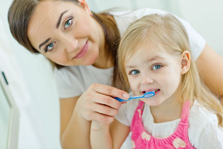Mother and duaghter brushing teeth